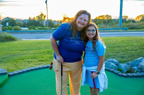 teacher and student at mini golf